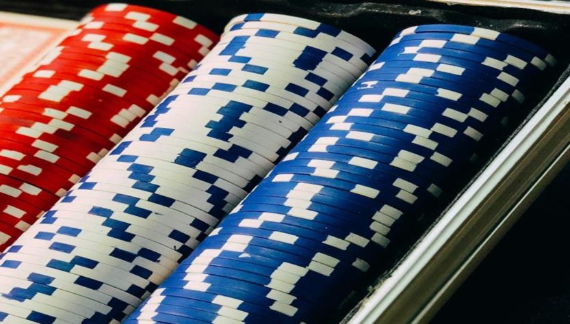 Stacks of red, white, and blue poker chips in a casino tray.