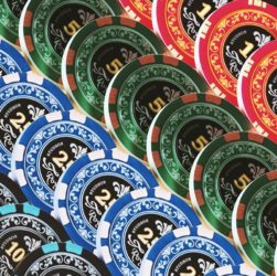 Pile of colorful poker chips in blue, green, red, and black, displaying denominations of 2, 5, and 10.
