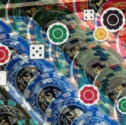 Colorful casino chips with white-edged circular control icons (red, green, yellow) and small dice motifs, indicating interactive game controls.