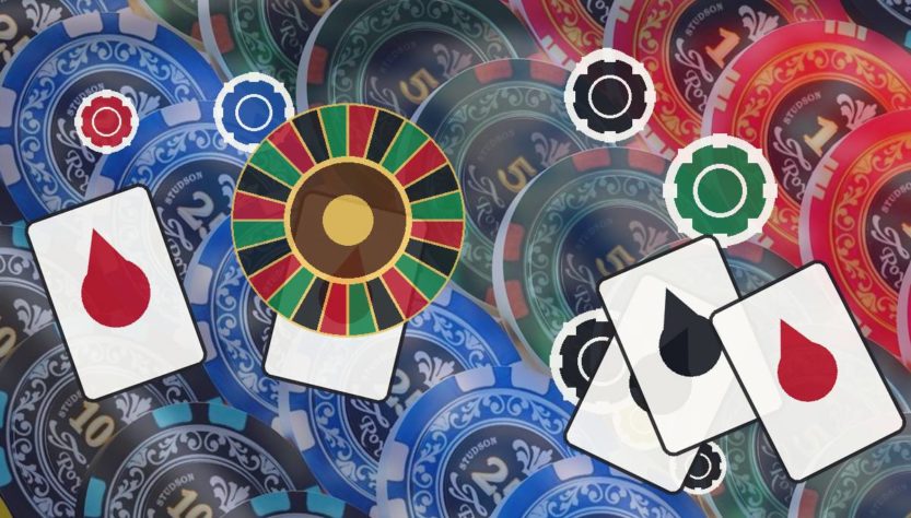 Hazbet-Yeni-Giris-Linkijpg - Hazbet Giriş Sitesi, Güncel Hazbet sayfası Assorted casino chips, playing cards with red and black drops, and a roulette wheel on a colorful table surface.
