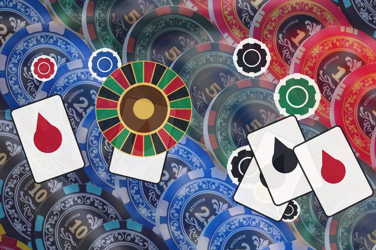 Assorted casino chips, playing cards with red and black drops, and a roulette wheel on a colorful table surface.
